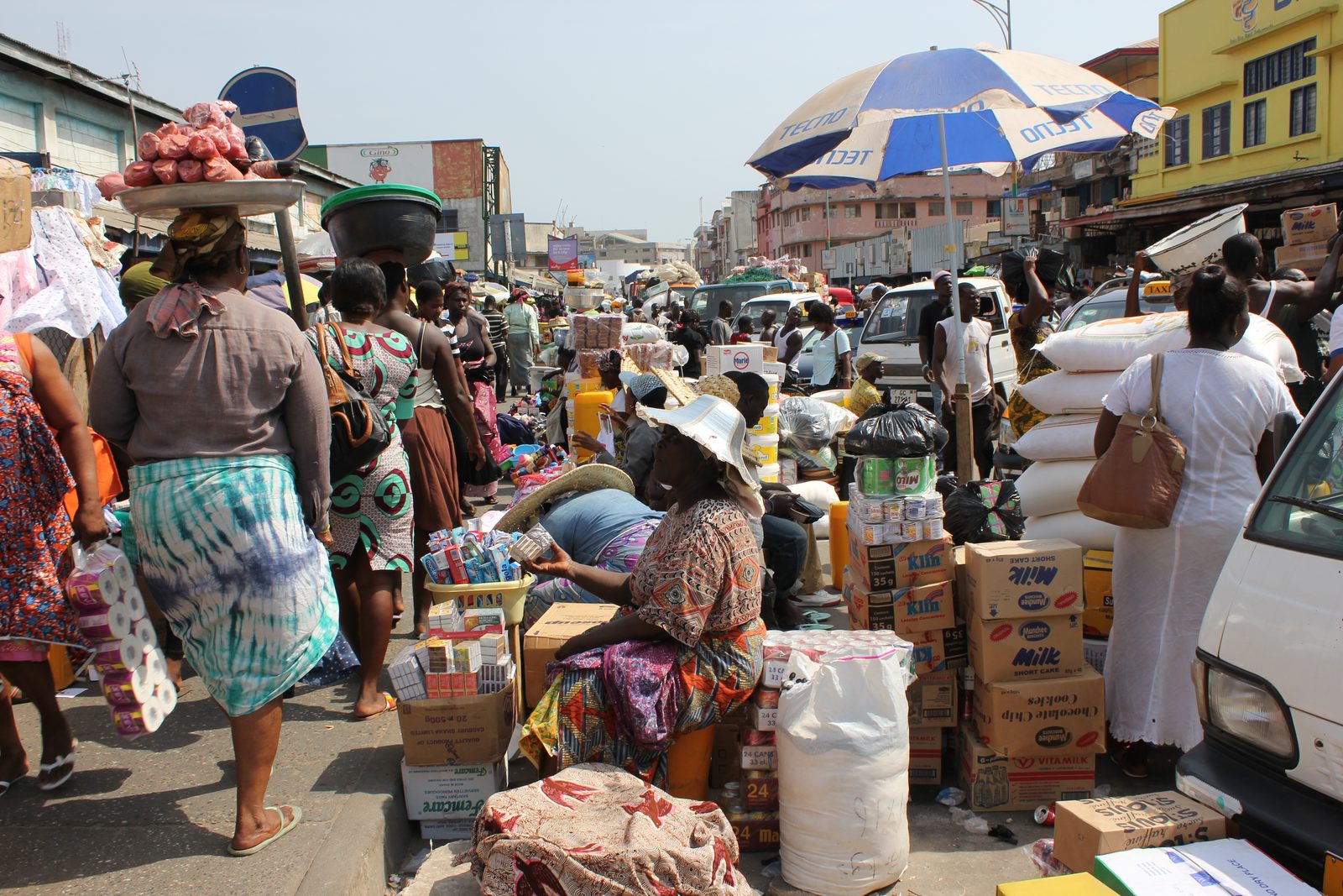 A busy street outside Makola Market in Accra, Ghana — traders and shoppers going about everyday life