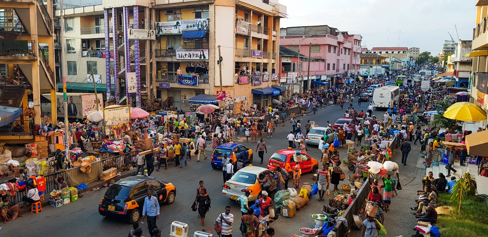 A street view of Accra Central, Ghana, showing traffic and pedestrians